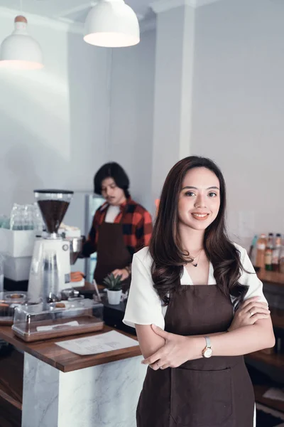 Aziatische café-eigenaar glimlachend naar camera — Stockfoto