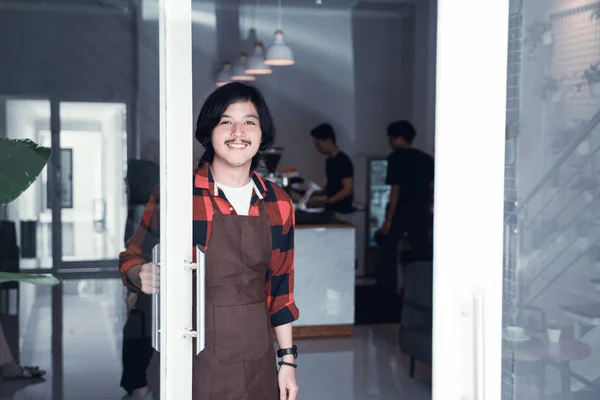 Barista Open de deur in zijn café gastvrij — Stockfoto
