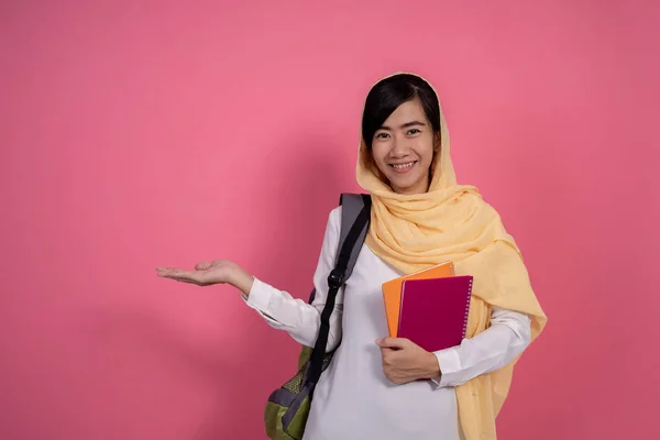 Šťastný mladý muslimský student usmívající se na růžovém pozadí — Stock fotografie