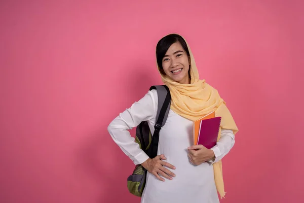 Muslimský student na růžovém pozadí — Stock fotografie