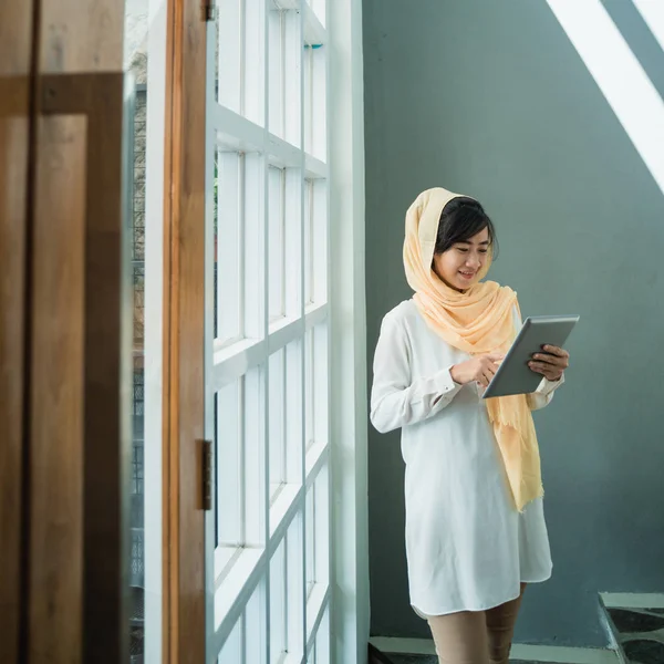 Moslimvrouw dragen hijab met behulp van tablet pc — Stockfoto