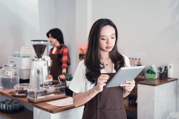 Jong aziatisch cafe werknemer met tablet. — Stockfoto