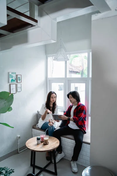 Asiatiska vänner njuta av att använda Tablet PC och prata med partner — Stockfoto