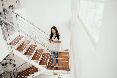 meşgul asya işçi merdiven kadar yürüyüş
