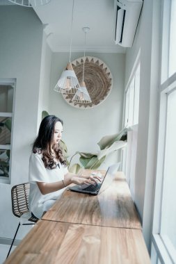 asyalı kadın kafede kendini çalışırken zevk