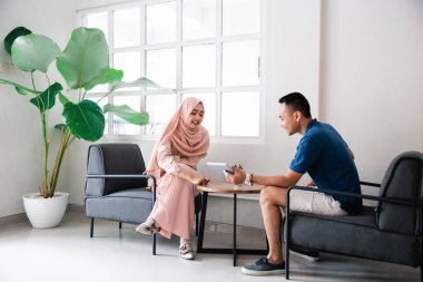 Genç çift rahatlarken tabletle geziniyor