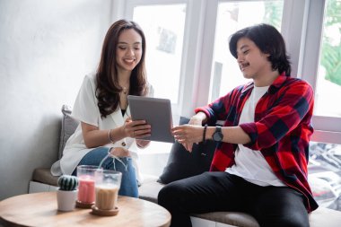 asyalı arkadaşlar tablet kullanarak ve ortağı ile konuşurken zevk