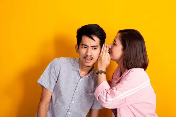 Man looked shocked while woman whispering to his ear — Stock Photo, Image