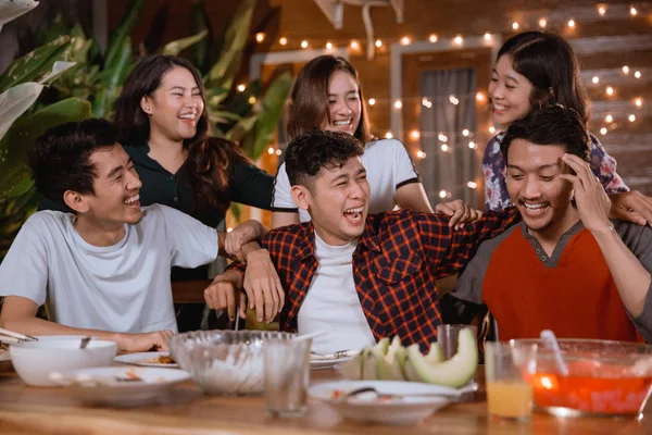 Divertidos jovens rindo enquanto fazem festa no jardim em casa — Fotografia de Stock