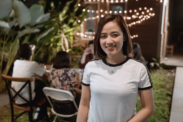 ディナーガーデンパーティーを持っている間、カメラに微笑む魅力的なアジアの女性 — ストック写真