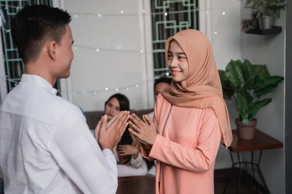 asian man and hijab woman greet each other apologizing