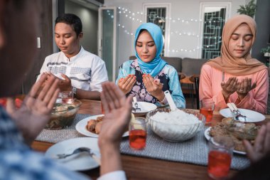 Hijab kadın ve bir adam yemeklerden önce birlikte dua