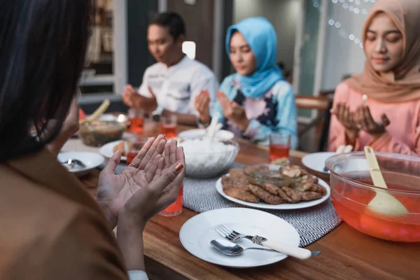 Hiyab mujeres y un hombre rezan juntos antes de las comidas —  Fotos de Stock