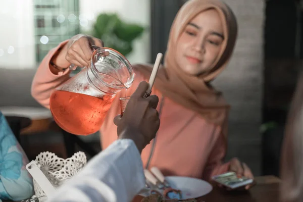 Veiled woman pours syrup in to a glass to break fast — Stock Photo, Image