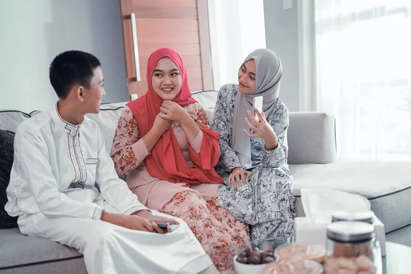 Tiga teman muslim duduk di sofa dan memiliki percakapan — Stok Foto