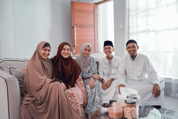 Keluarga muslim yang bahagia duduk di sofa di rumah — Stok Foto