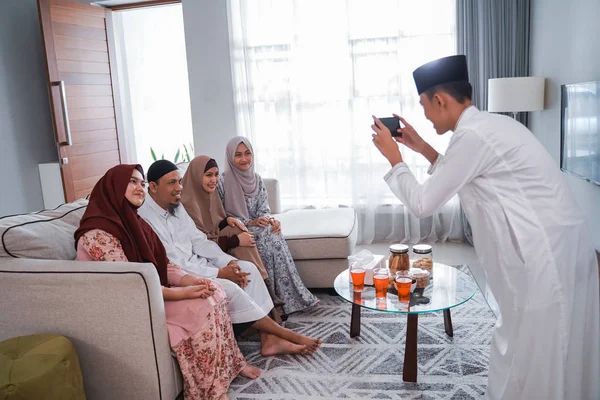 Laki-laki muslim mengambil gambar keluarganya sambil duduk di sofa — Stok Foto