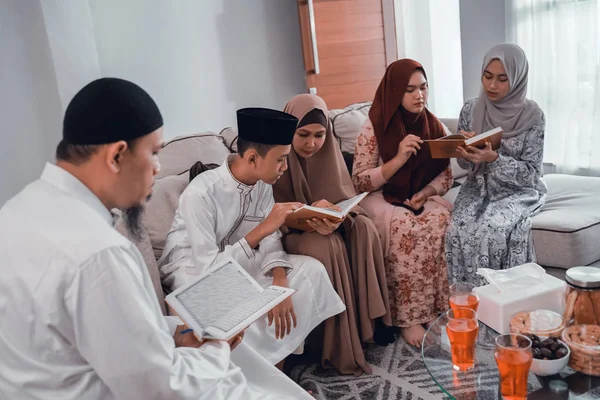 Muslim family reading quran together in livingroom — Stock Photo, Image