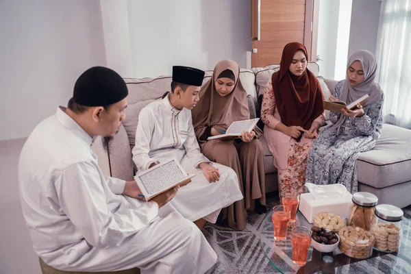 Muzułmańska rodzina czyta razem Koran w salonie — Zdjęcie stockowe