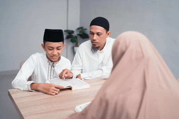 무슬림 아버지는 자신의 아들을 가르치는 방법 에 읽기 꾸란 — 스톡 사진