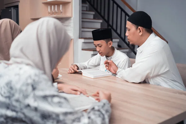 Μουσουλμάνος πατέρας διδάσκει το γιο του πώς να διαβάσει Κοράνι — Φωτογραφία Αρχείου