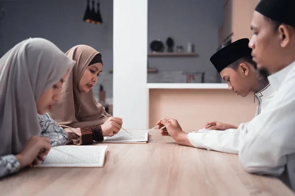 Muslim familj läser Koranen eller helig bok av islam tillsammans — Stockfoto