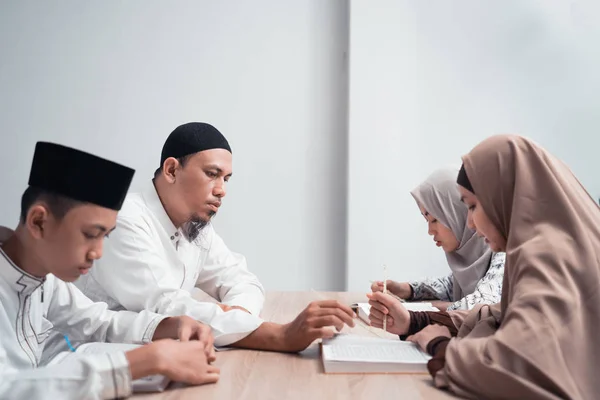 Muslim familj läser Koranen eller helig bok av islam tillsammans — Stockfoto