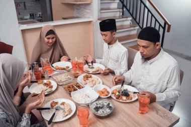 Müslüman aile yemekten önce birlikte dua eder.