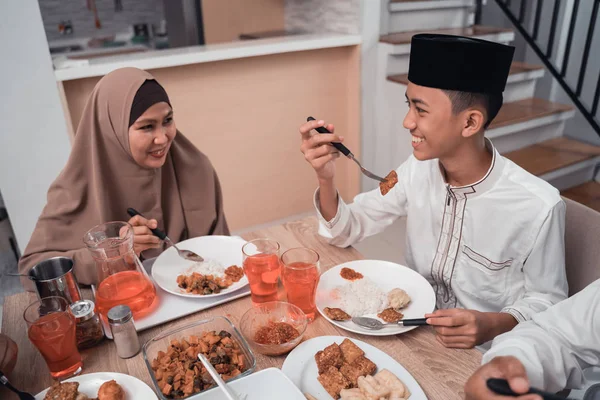 Muzułmańska matka rozmawia z synem podczas kolacji razem — Zdjęcie stockowe