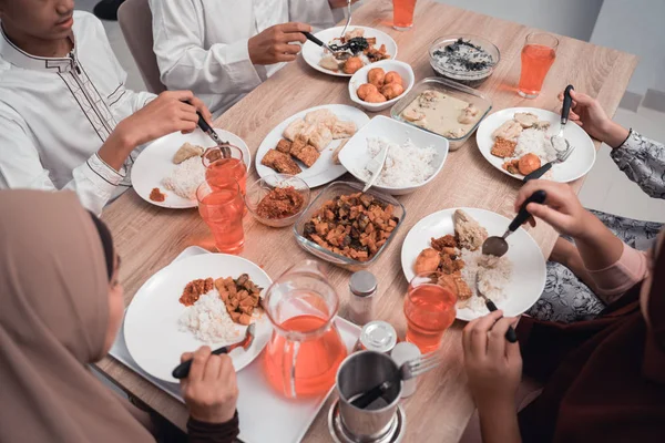 Close up de mão comendo na mesa de jantar juntos — Fotografia de Stock