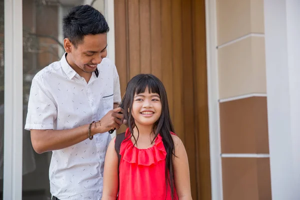 Тато допомагає дочці розчісувати волосся — стокове фото