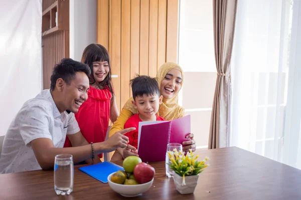 Família lendo um livro juntos — Fotografia de Stock