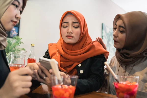 Хиджаб женщины и друзья грустные, когда читают плохие новости — стоковое фото