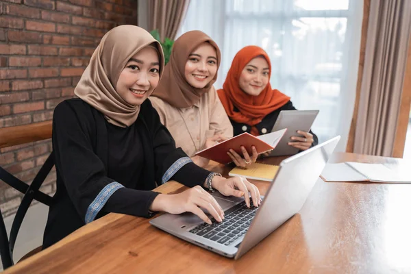 Young beautiful woman veiled smiling looking the camera when sitting with laptop, tablet, and book — Stock Photo, Image