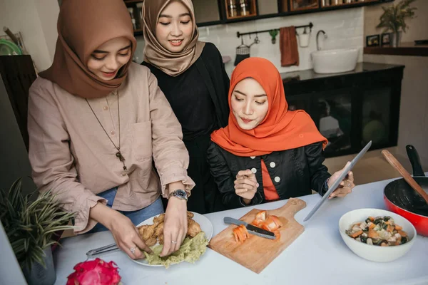 Hijab mulher e amigos chapeamento de uma cozinha na cozinha — Fotografia de Stock