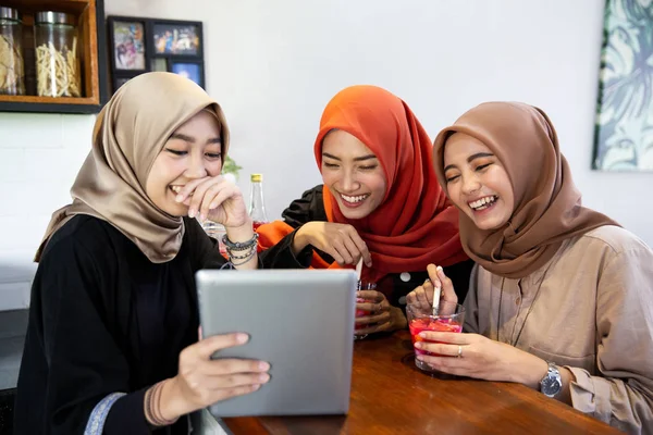 Verschleierte junge Frauen entspannen sich im Chat und scherzen mit digitalen Tablets — Stockfoto