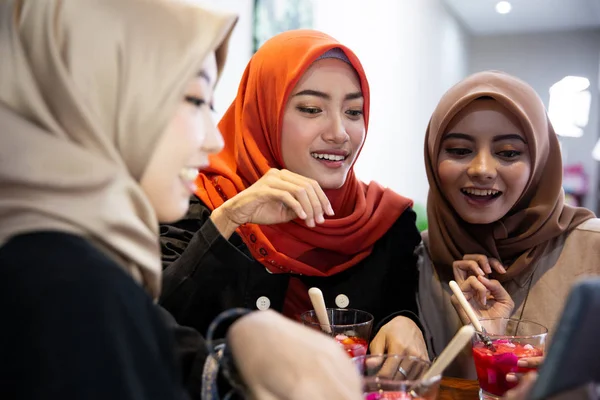 Hidżab kobiet i przyjaciół za pomocą cyfrowego tabletu podczas oczekiwania łamanie ich szybko — Zdjęcie stockowe