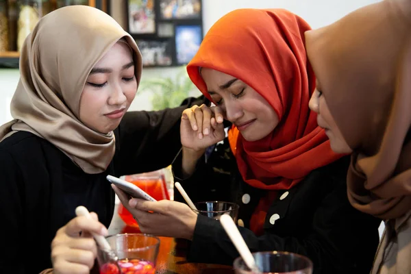 Hijab women and friends sad when reading bad news — Stockfoto