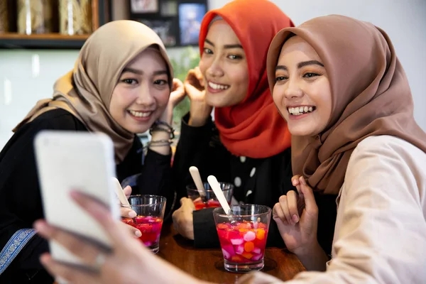 Verschleierte junge Frauen entspannen sich mit Smartphone für Selfie — Stockfoto