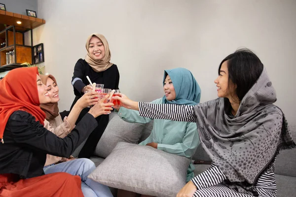 Veiled women drink cheers when breaking their fast