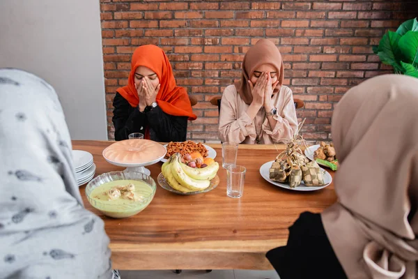 Hijab women pray together before meals