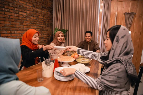 Хіджаб жінка дає тарілку членам сім'ї — стокове фото