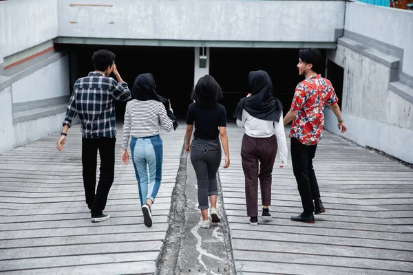 Bakifrån av unga vänner gå iväg tillsammans — Stockfoto