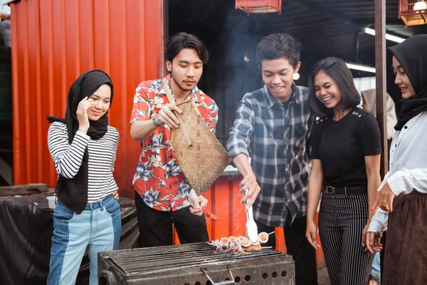 Grupo de amigos grelhar comida com um espeto — Fotografia de Stock