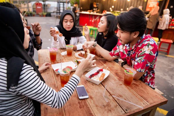 Sekelompok teman muda menikmati makanan di luar ruangan — Stok Foto