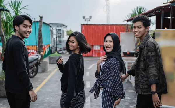 Jóvenes amigos se alejan posando en el camino juntos — Foto de Stock