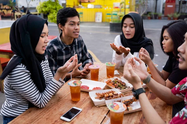 Grupo de jóvenes amigos disfrutando de la comida al aire libre — Foto de Stock