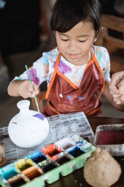 boya fırçası ile çocuk boyama seramik çömlek