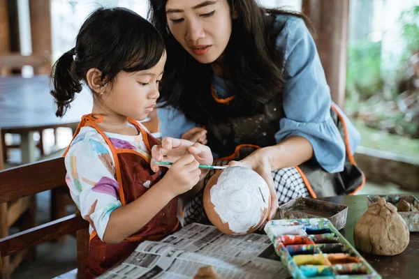 Madre e hija pintando olla de cerámica —  Fotos de Stock