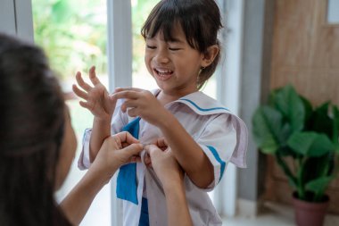 küçük çocuk annesi ile sabah okula hazırlanıyor